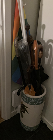 Paraplyställ med regnbågsflagga och käppar