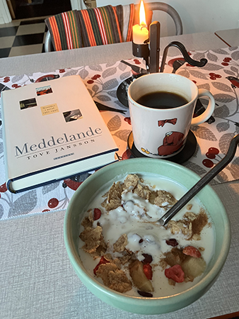 Frukostfil med tänt ljus o boken Meddelande