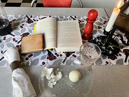 Ägg bok o tänt ljus vid köksbordet