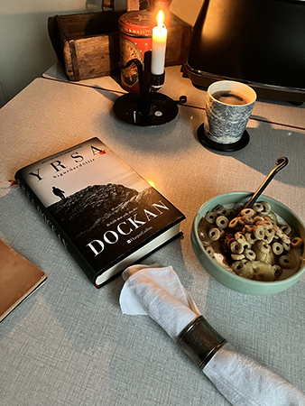 Frukost med tänt ljus havreringar i filen boken Dockan