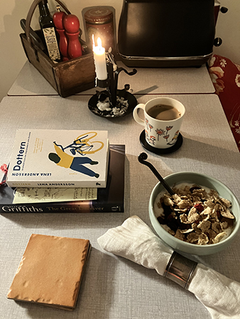 Vardagsfrukost med två böcker och tänt ljus