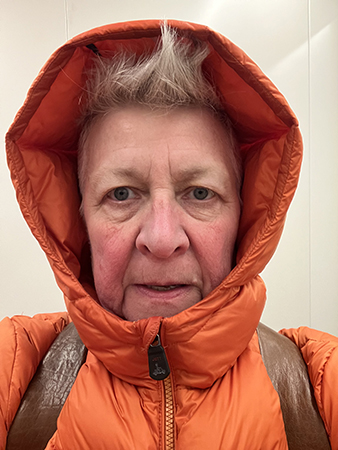 Frusen i orange jacka med luva selfie