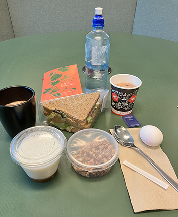 Lunch med yoghurt müsli trekantsmacka kokt ägg varm choklad bok o vatten