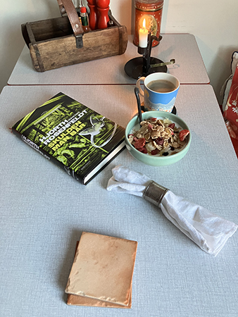 Torsdagsfrukost med tänt ljus o boken Skulden vi bär