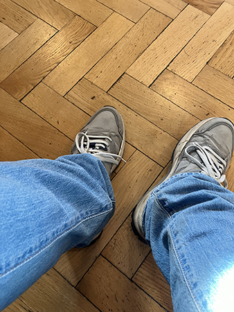 Mina fötter på parkettgolvet i väntrummet på mottagningen