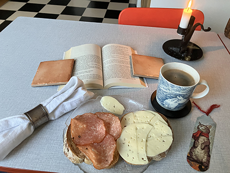 Kaffe mackor o bok o tänt ljus till kvällsmat