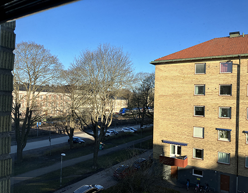 Solig morgon över grannhus o parkering sista april