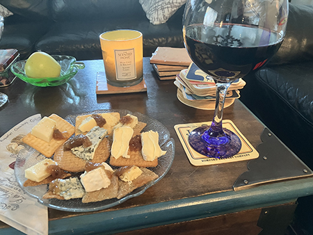 Assiett med ost och kex och ett glas amarone