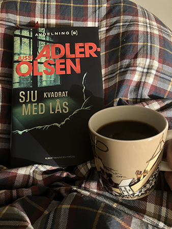 Boken Sju kvadrat med lås och kaffe på sängen