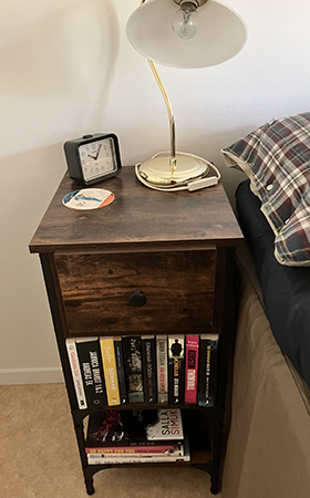 Sängbord med TBR-hyllor vid sängen