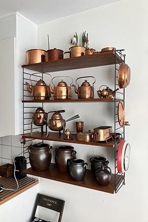 Stringhyllan med kopparsaker och Höganäskrus