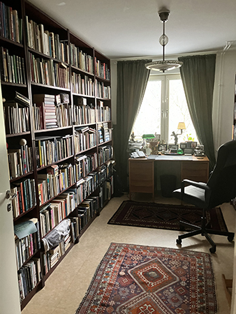 Ett rum med böcker mattor och gardiner