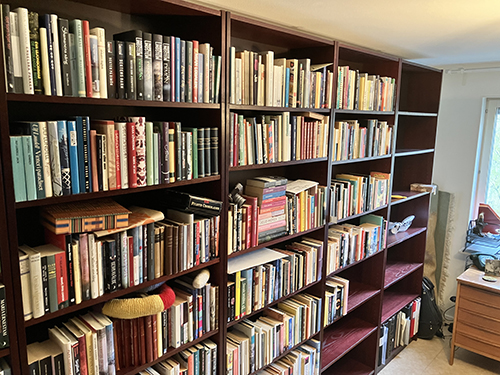 Påfyllda bokhyllor och en bit skrivbord