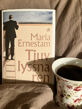 Boken Tjuvlyssnaren och kaffe på sängen i söndagsmuggen