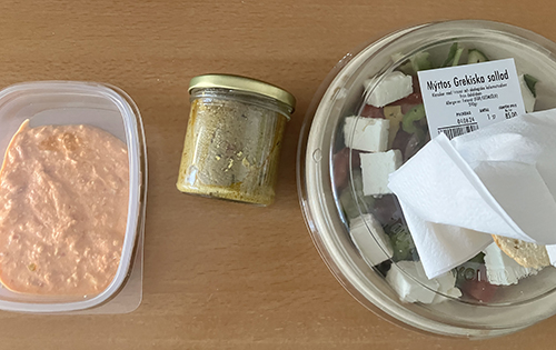 Fetaoströra tapenade och grekisk sallad med bröd i servetten