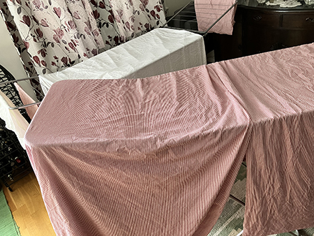 Lakanstvätt på torkställningar i vardagsrummet