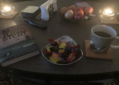 Boken Den sista utposten godisskål äppleskål kaffe på vardagsrumsbordet