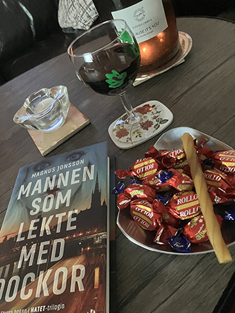 Lördagsgodis tänt ljus vinglas boken Mannen som lekte med dockor