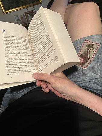 På soffan med bok i knäet