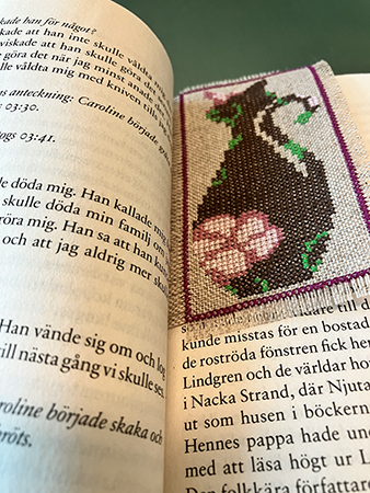 Bokuppslag med Vs kattbokmärke