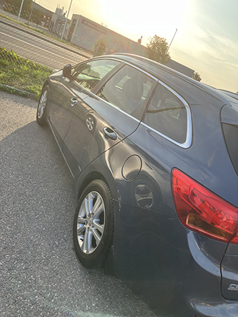 Bilen i augustimorgonsol på plåtverkstans parkering