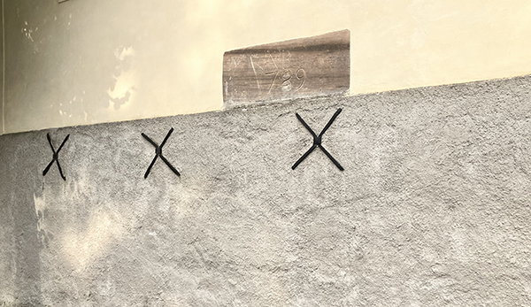 Tre kryss på en husvägg