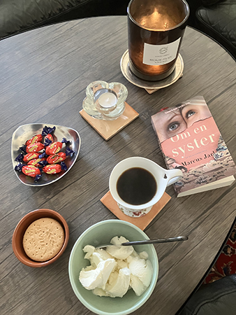 Kvällskaffe med glass digestive dumlekolor och boken Om en syster