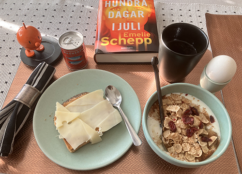 Lördagsfrukost med orange Hopptimisten och orange boken Hundra dagar i juli