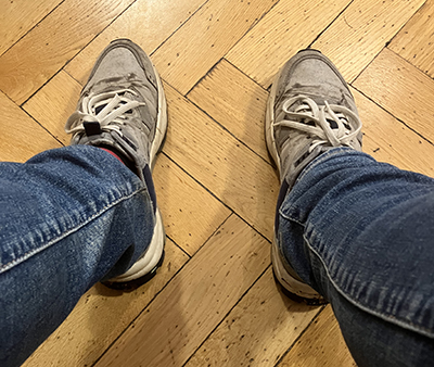 Mina jeansben och gråa jympadojor på väntrummets parkettgolv