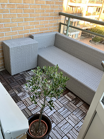 Balkongen med soffa och olivträd