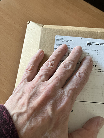 Brunt paket med min hand på