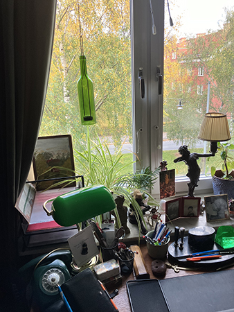 Ljusflaska grön i fönstret i arbetsrummet