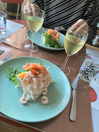 Lisbeth och jag äter smörgåstårta och dricker vitt vin hos mig