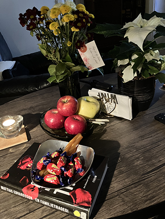 Godis bok äpplen och blommor på vardagsrumsbordet