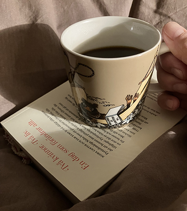 Muminmugg med kaffe på boken Andra kvinnors liv