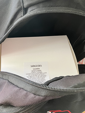 Låda med en bit smörgåstårta i ryggsäcken