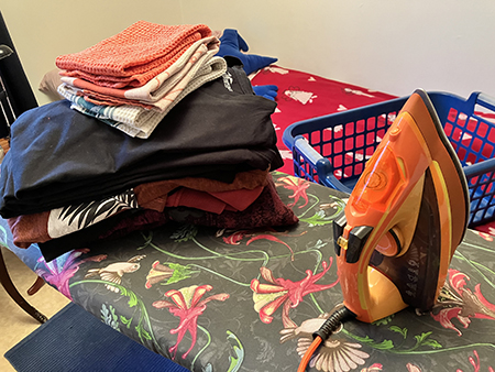 Strykhög och orange strykjärn på strykbrädan