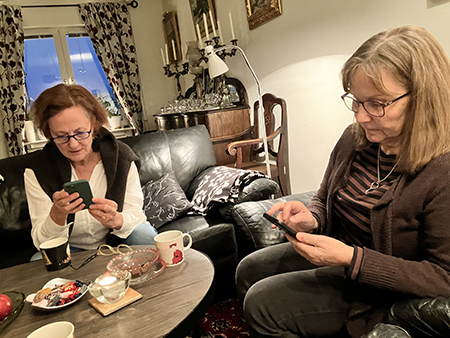 Gunilla o Birgitta med mobiler i vardagsrummet fika