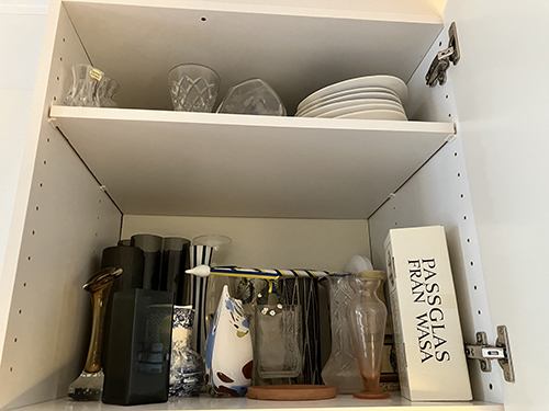 Mina vaser på två hyllplan i ett skåp