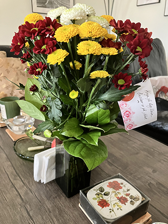 Blommorna från jobbet i vas på vardagsrumsbordet