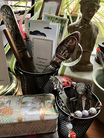 Bokmärken och brevsprättar i svarta metallburkar på skrivbordet