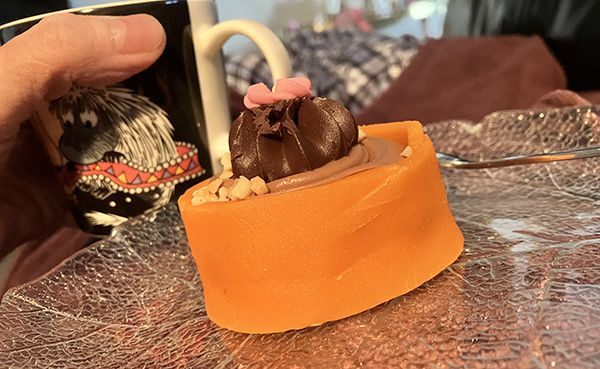 Fikar liggande med Noisette och muminmugg