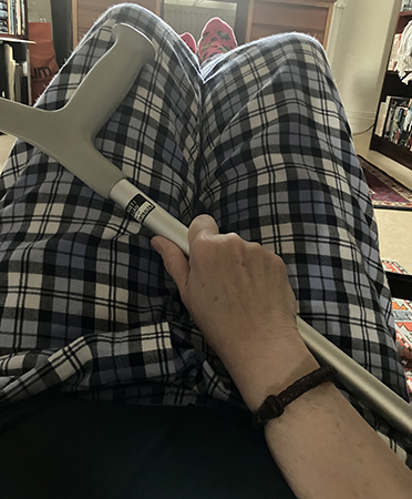 På golvet med benen på pall o krycka i hand På golvet med benen på pall o krycka i hand