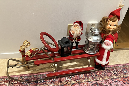 Röda kälken i hallen med tomtar lyktor och julbockar