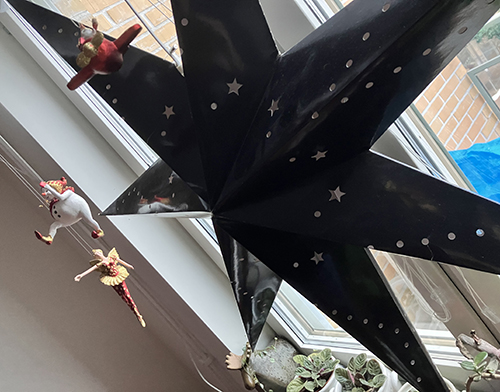 Släckt svart stjärna o julfigurer i köksfönstret