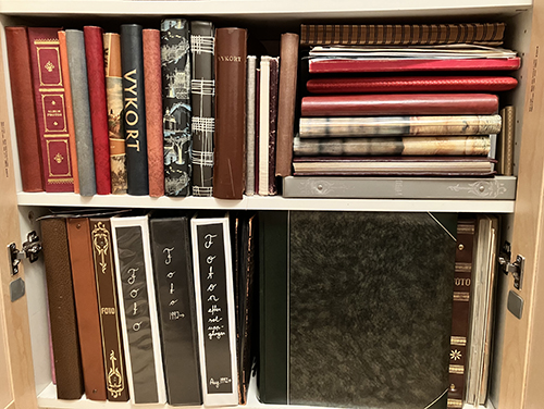 Album genomgångna i hylla bakom dörrar