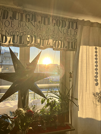 Sol genom köksfönstret med svart adventsstjärna o julkappa