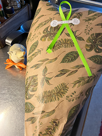 Köksgrisen är nyfiken på blompaketet från Nya Björck blomsterhandel