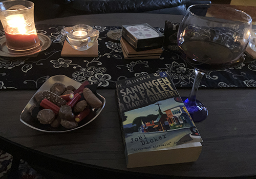 Godisskål boken Sanningen om fallet Harry Quebert o en skvätt vin i ett glas