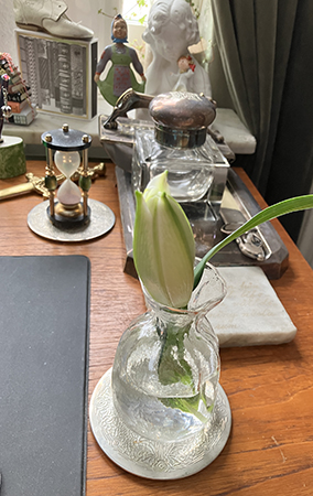 En avbruten lilja i vas på skrivbordet